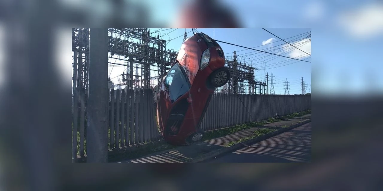 Carro desgovernado bate contra muro e fica pendurado em fios de alta tensão