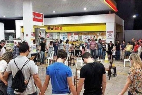 Imagem de grupo rezando em posto de combustível para baixar preços  é fake