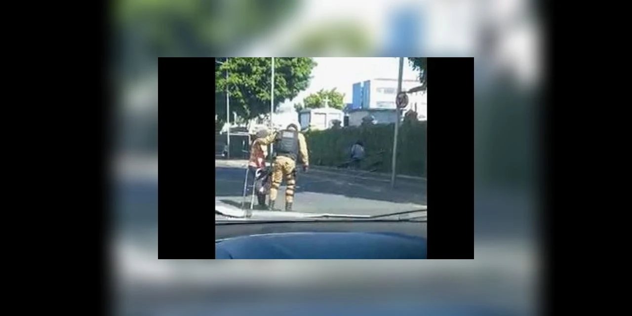 Policial para o trânsito para ajudar idosa atravessar avenida em PG