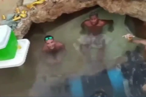 Homens tomam banho e bebem cerveja dentro de buraco de obra, em Belém